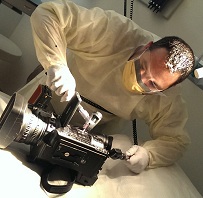 Cliff Erwin, Broadcast Studio Manager, Medical News Network, gowned up for the operating room, shooting video.